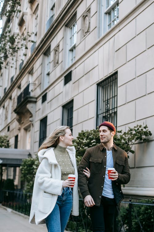 Couple walking on street with coffee cups