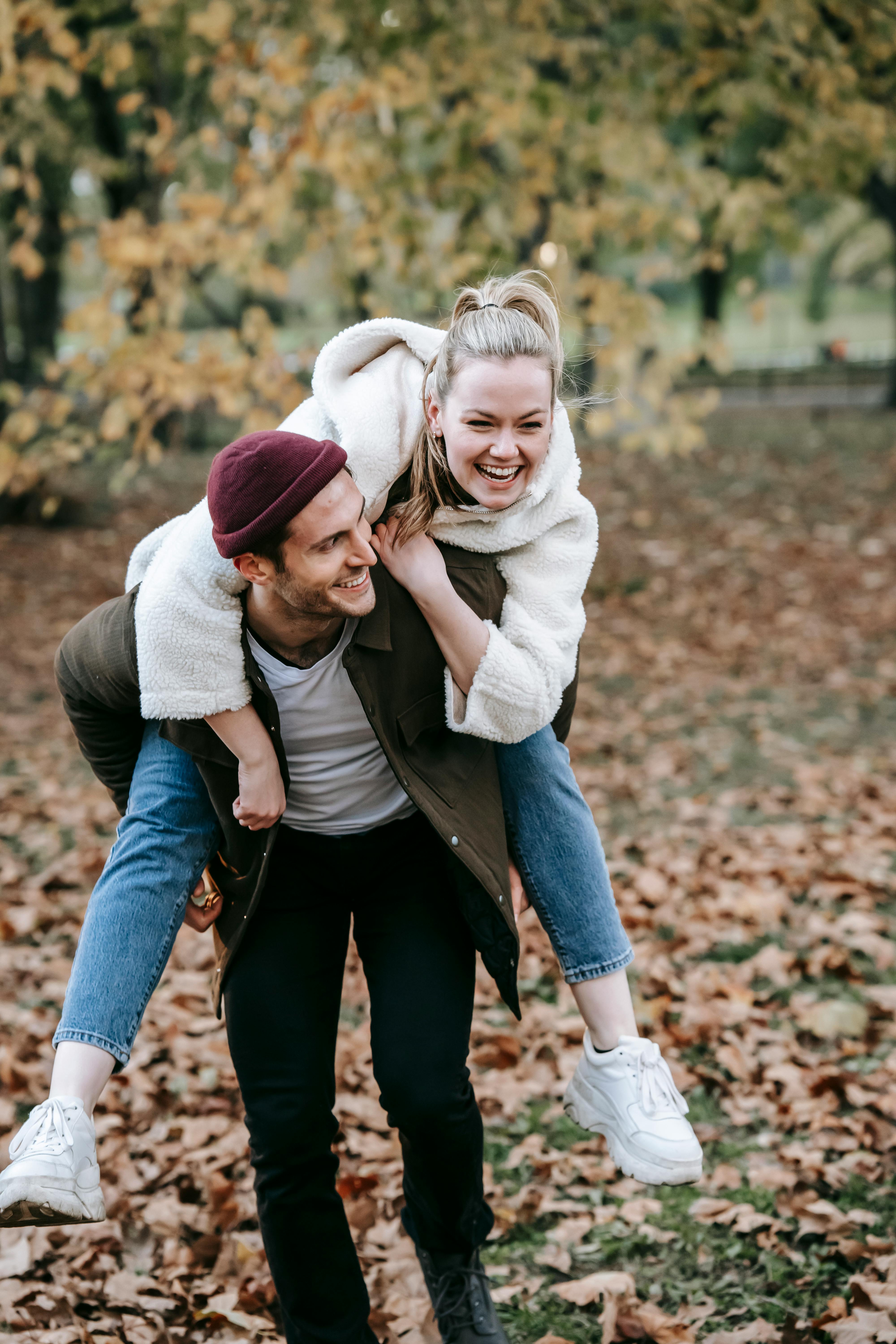 couple enjoying piggyback ride in park