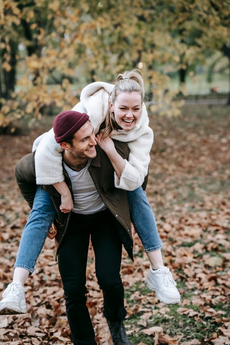 Couple Enjoying Piggyback Ride In Park