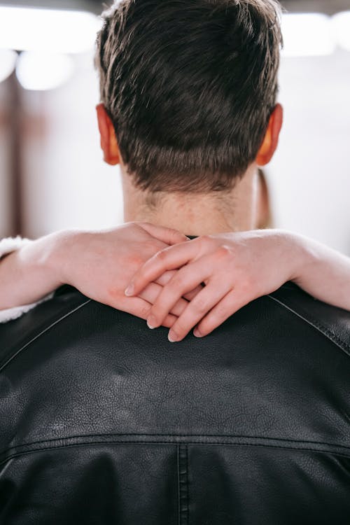 Anonymous woman hugging neck of unrecognizable man