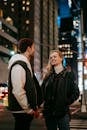 Cheerful couple standing on roadside in city