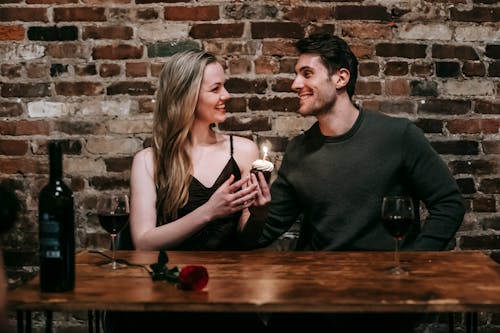 Positive couple with cupcake celebrating event in cafe