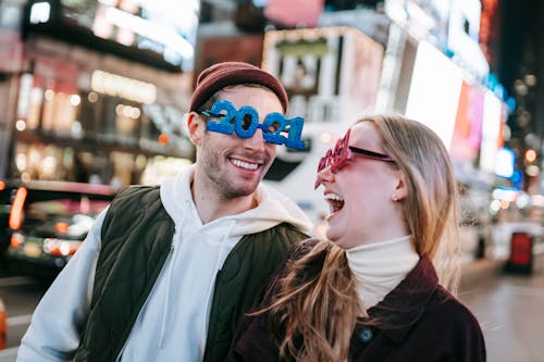 Overjoyed couple in 2021 glasses on street