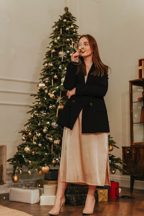 Woman In Black Blazer And Skirt Standing Beside Green Christmas Tree
