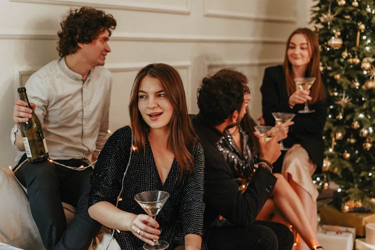 Group Of People Sitting On A Couch Holding Drinks