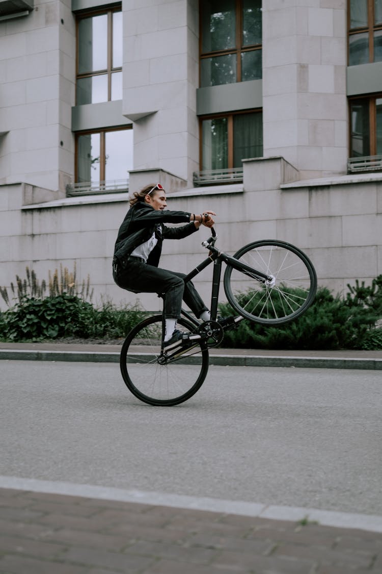 Man In Black Jacket Riding On Bicycle