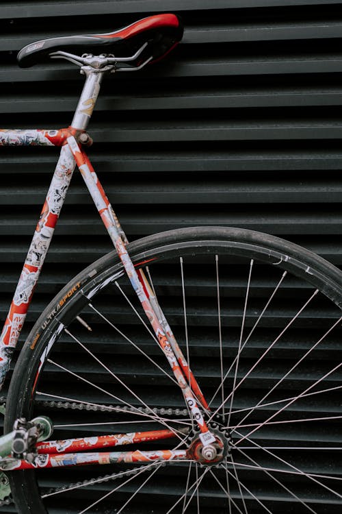 Kostenlos Rotes Und Schwarzes Fahrradrad, Das Auf Schwarze Hölzerne Wand Stützt Stock-Foto