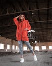 A Woman Wearing Red Jacket Standing on Concrete Floor