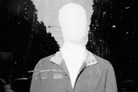 White mannequin against city street