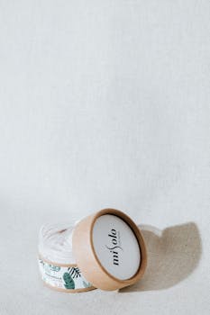 Cream jar with beige lid and decorative design, close-up with copy space.