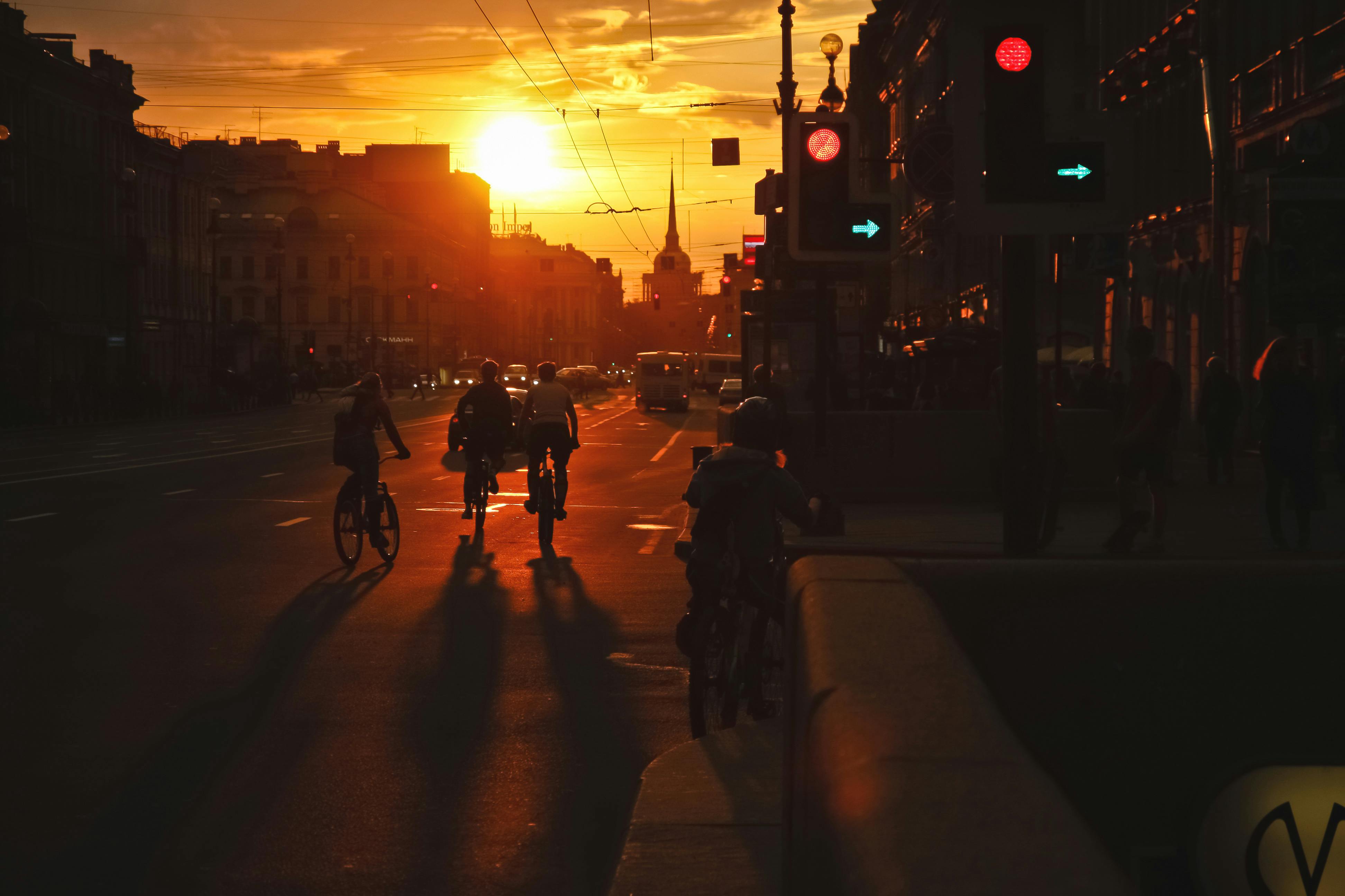 people walking and rising bicycles in evening at sunset