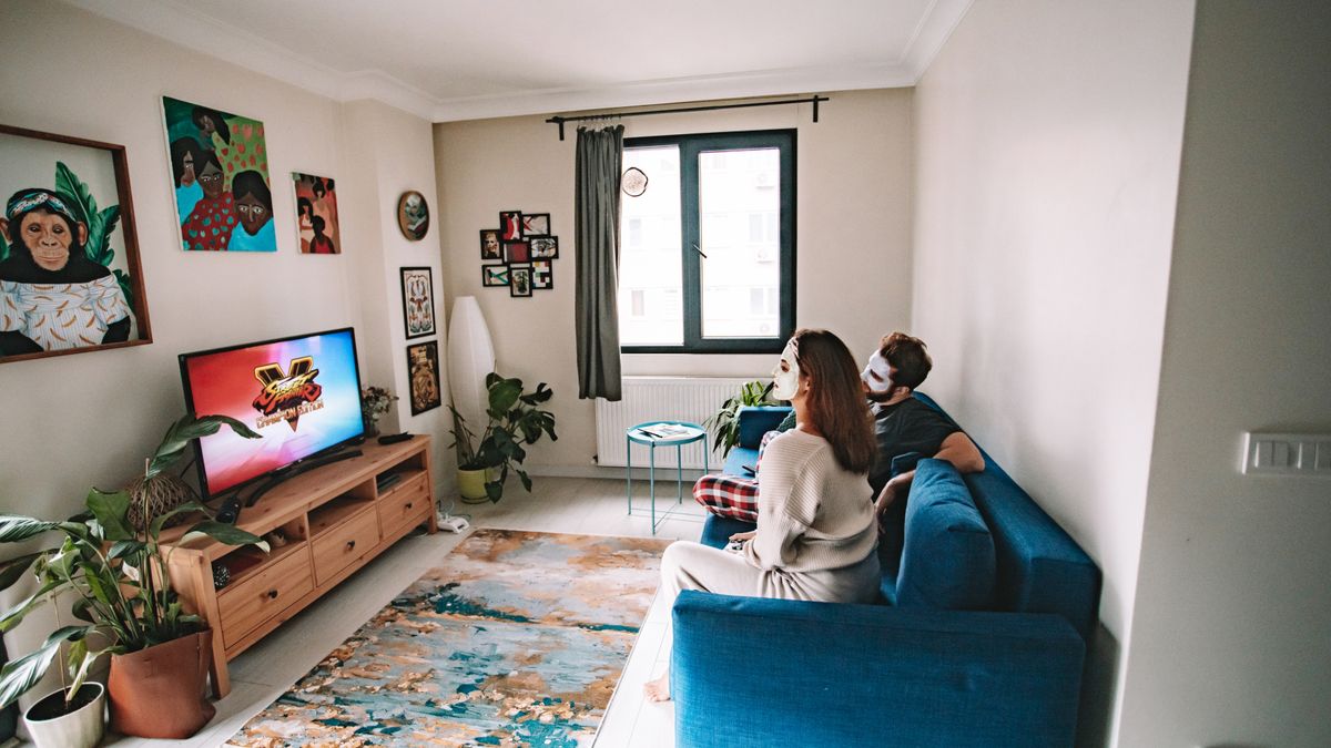 リビングでテレビを見てくつろぐカップル