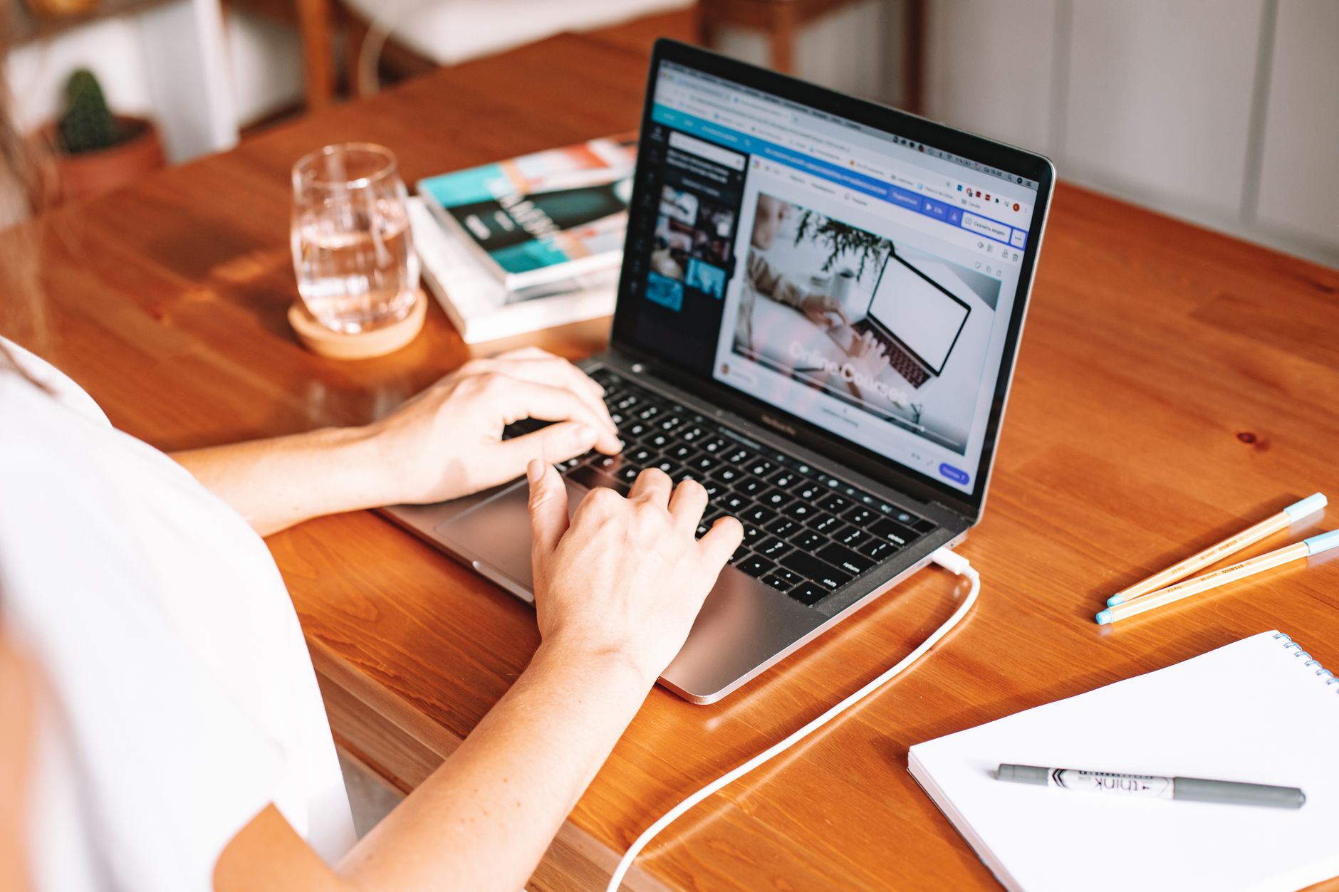 Freelancer working on laptop with notes on desk