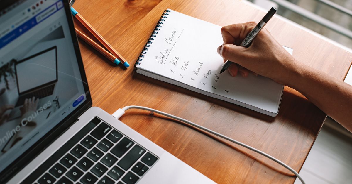 Ordinateur portable et carnet de notes manuscrites pendant une séance d’étude
