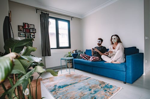 Man and Woman Sitting on a Sofa Playing a Video Game