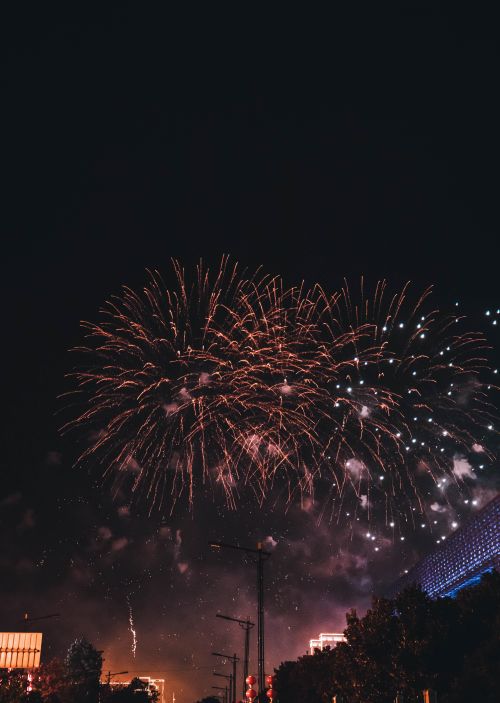 Free A breathtaking view of colorful fireworks lighting up the night sky above a vibrant cityscape. Stock Photo