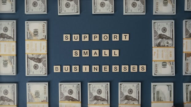 Top view of dollar bills and letter tiles promoting small businesses.