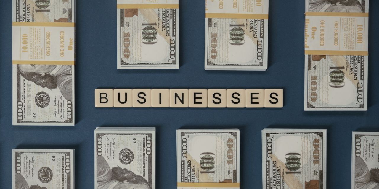 Cash and letter tiles spelling business on a desk