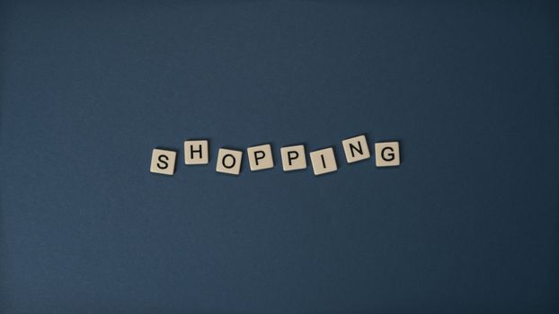 蓝色背景上，字母瓷砖拼出“购物”字样，非常适合零售主题