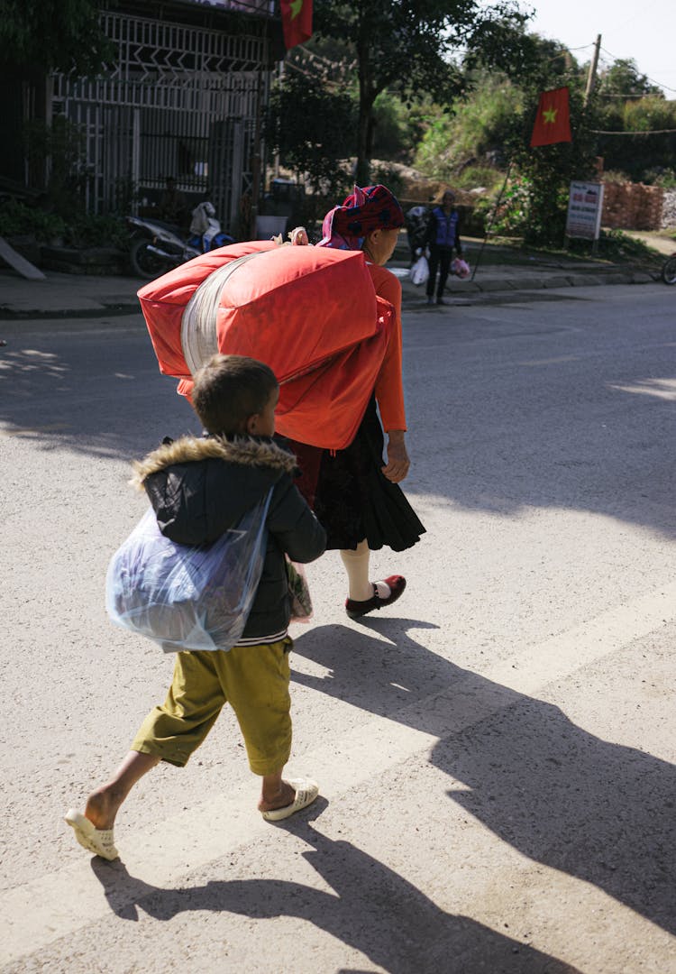 Woman And Her Son Carrying Bags On Their Bags 