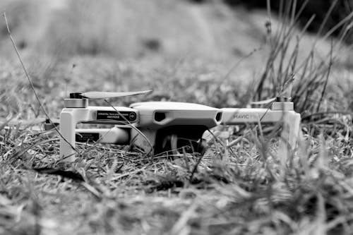 Black and white of contemporary drone located on grass of field in countryside