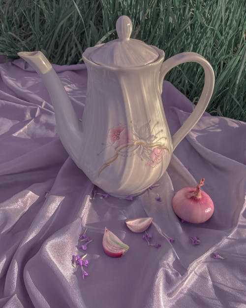 Free Ceramic teapot and onion on silk cloth Stock Photo