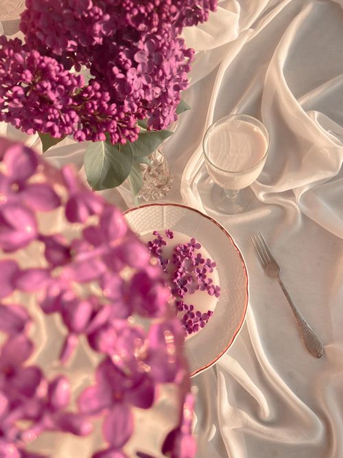 Free Top view composition of bouquet of fresh lilac and blooms in ice with goblet of milk placed on white fabric Stock Photo