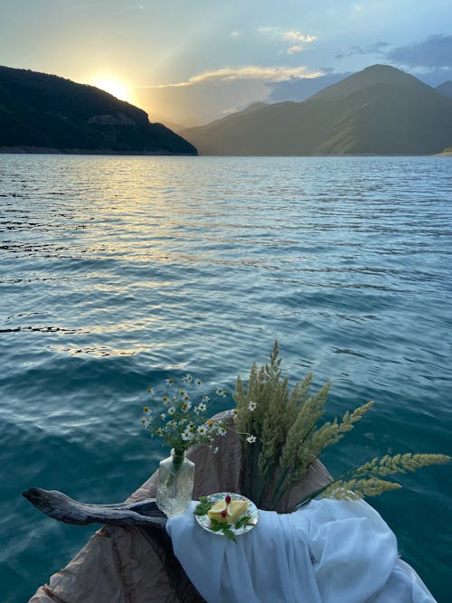 Boat with vase of flowers and dried grass on lake