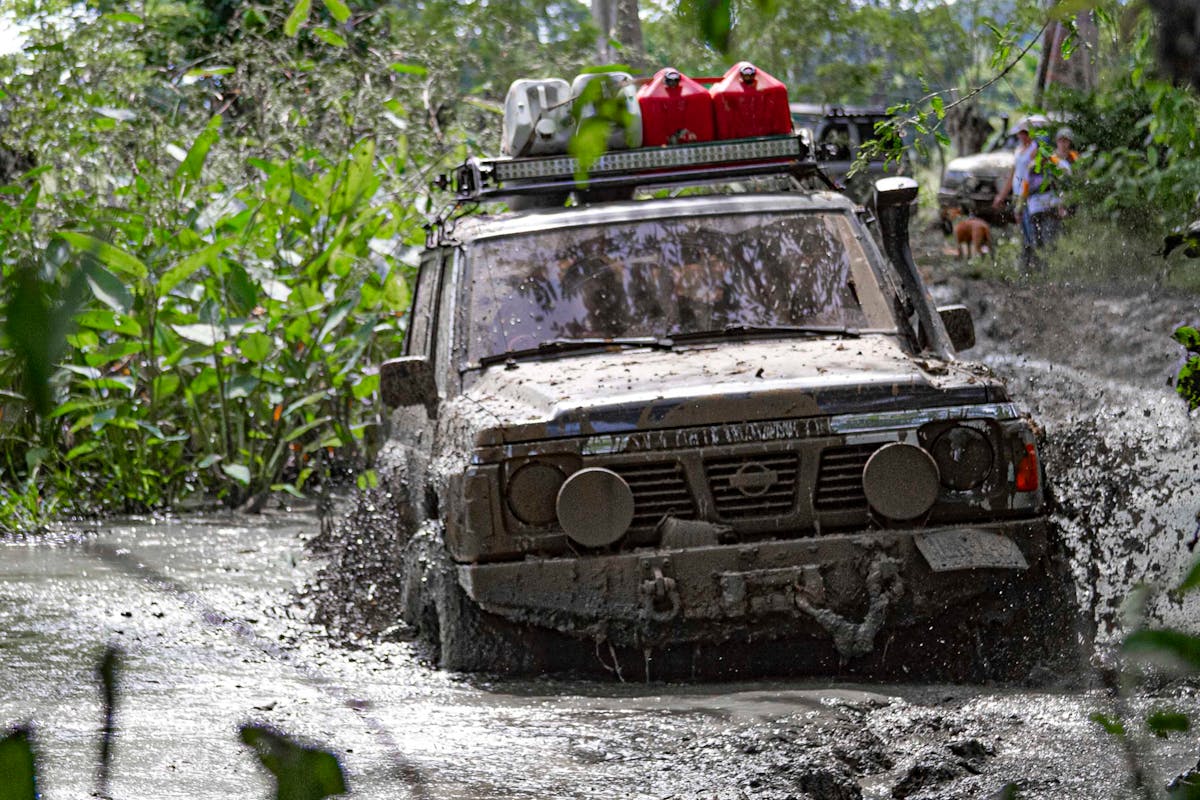4x4 vehicle navigating a muddy off-road trail where winch recovery gear is essential