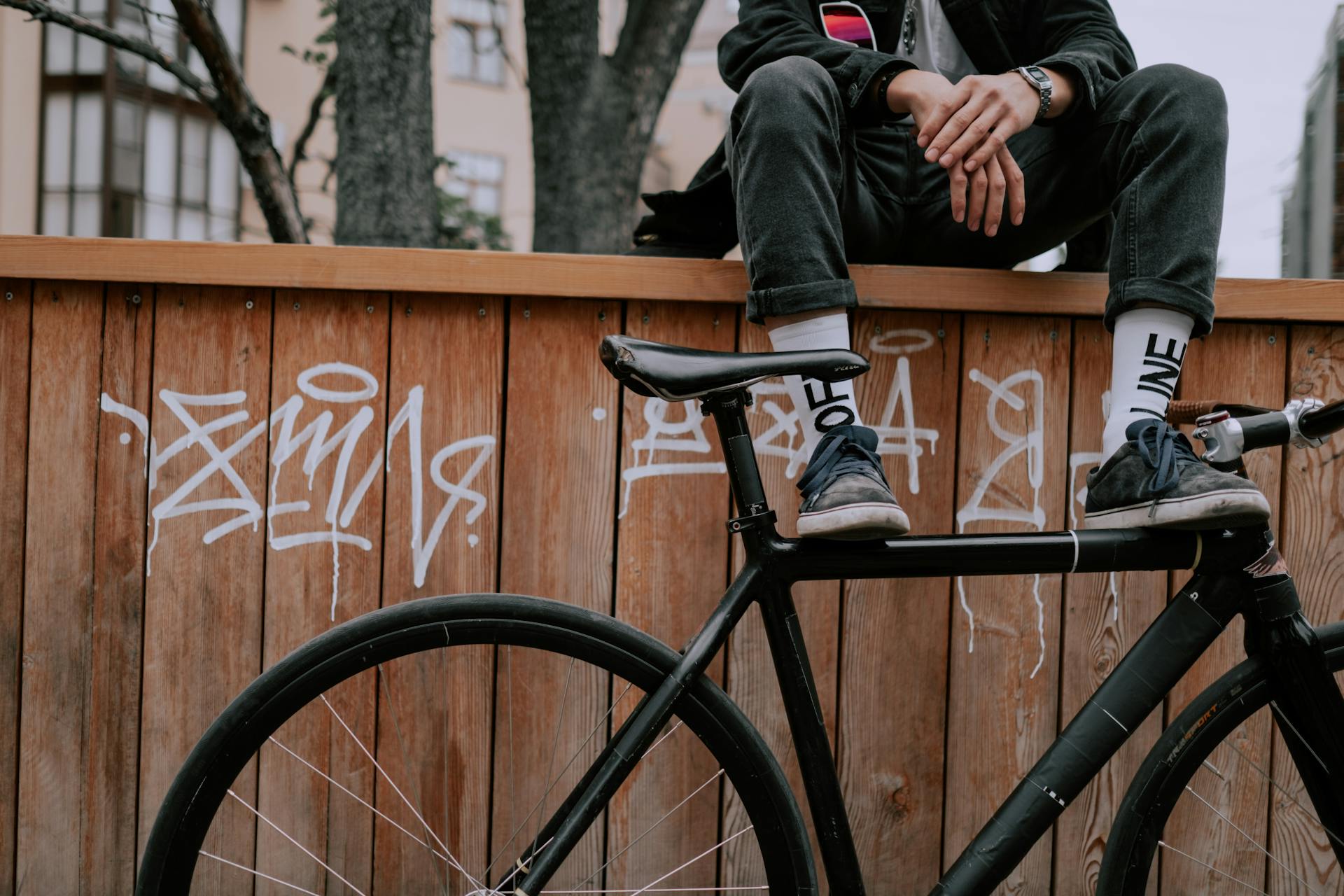 A Person Sitting on Wooden Fence