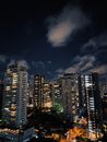 在戏剧性的夜空下，充满活力的城市天际线展示出明亮的摩天大楼