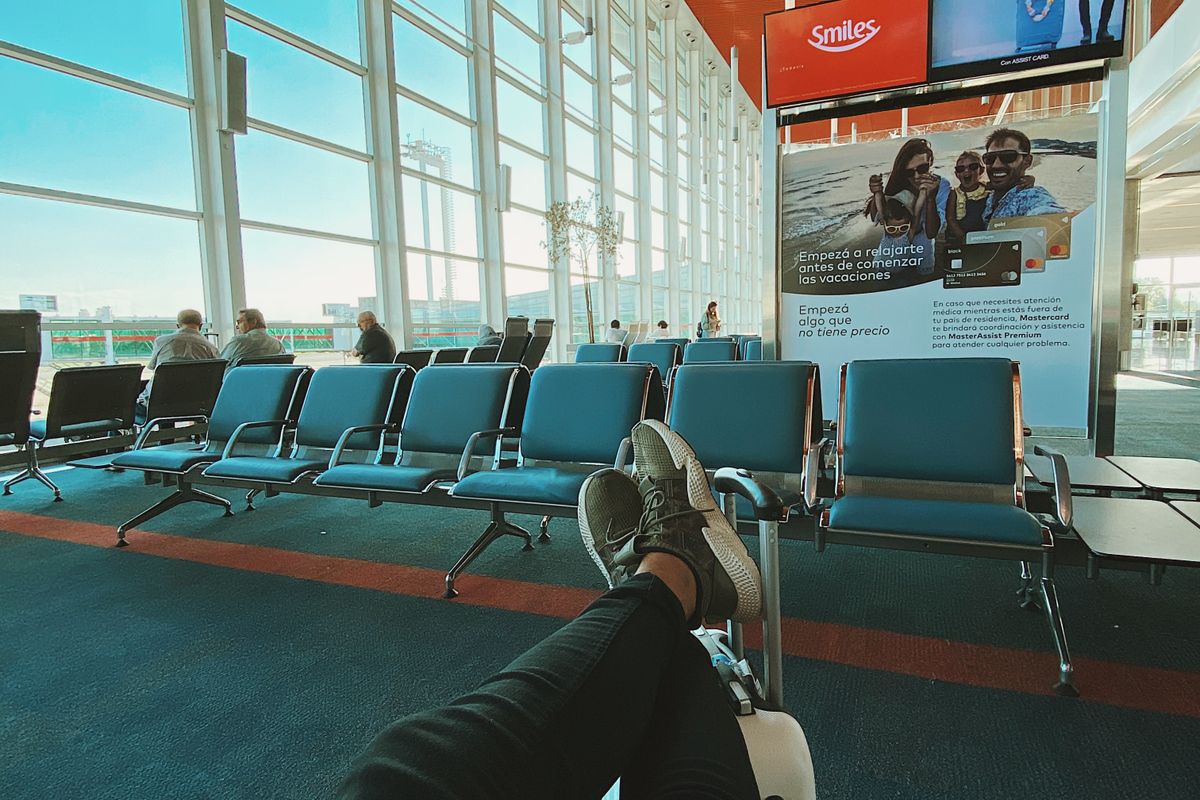 Traveller waiting in an empty row of airport seats
