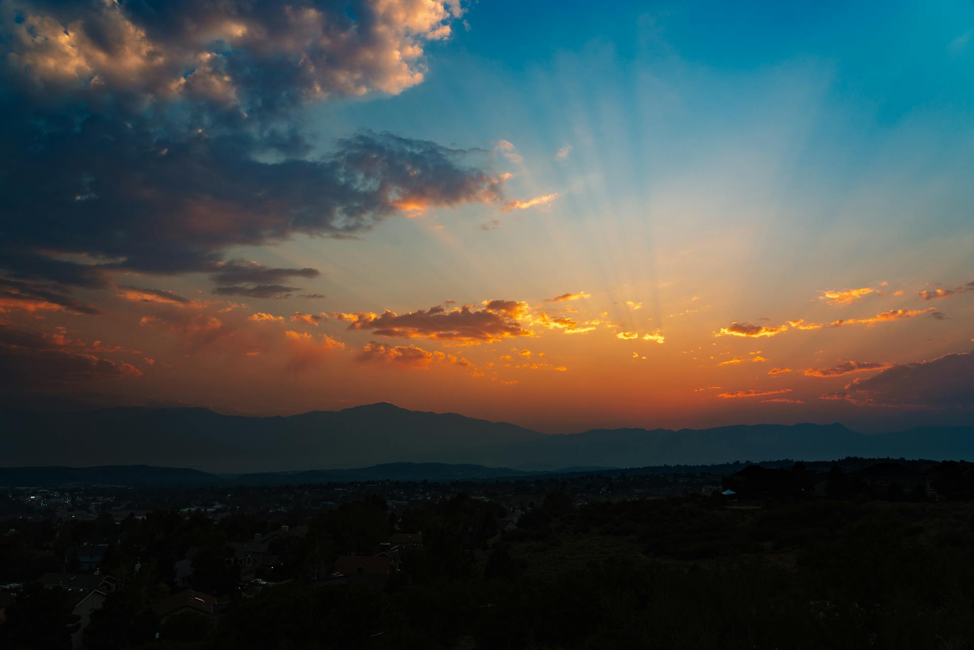 Breathtaking Colorado Springs sunset with vibrant clouds and mountain silhouette.