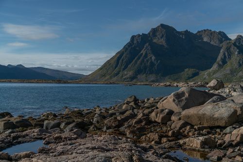 Free Picturesque view of calm blue water surrounded by rocks and hills under blue sky in sunny summer day Stock Photo