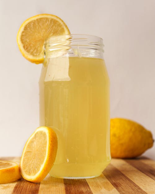 Free Clear Glass Jar With Yellow Liquid and Sliced Lemon Stock Photo