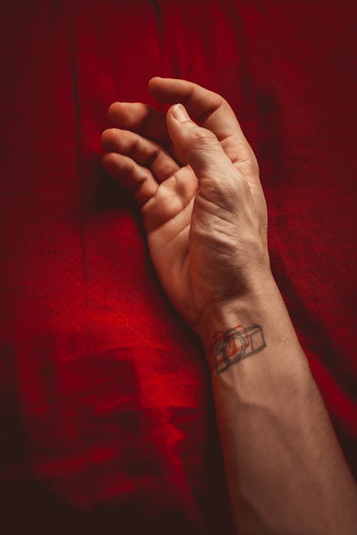 Persons Left Hand With Black Tattoo
