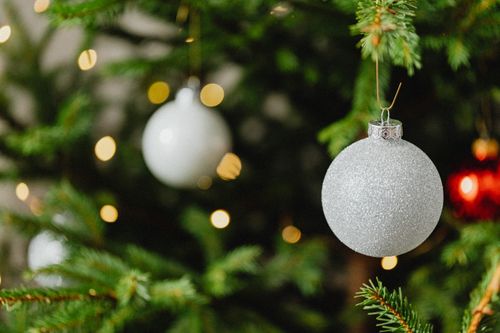 Free Close-up of a sparkly ornament hanging on a festive Christmas tree branch. Stock Photo