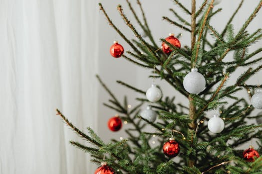A beautifully decorated fir tree with red and white ornaments, perfect for holiday celebrations.