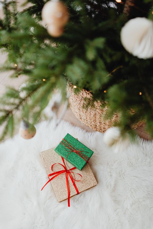 Free Cozy Christmas scene with beautifully wrapped gifts under a decorated tree, evoking festive warmth. Stock Photo