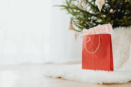 Red Gift Bag on White Fur Carpet