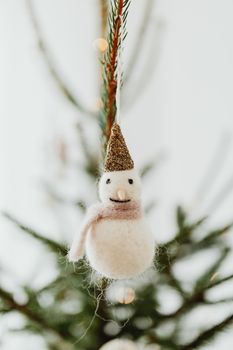 可爱的雪人装饰品挂在圣诞树枝上，增添了节日的欢乐