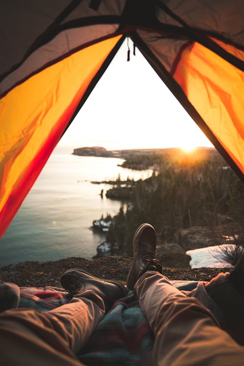 Турист, лежащий в палатке для кемпинга на берегу