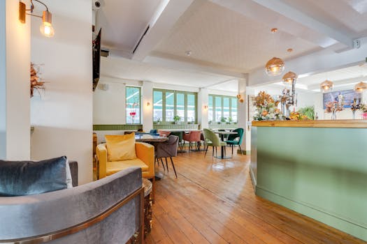 Trendy coffee shop interior with colorful seating, wooden floors, and bright windows.