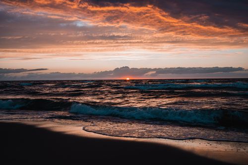 Free Vibrant sunset over waves at the Baltic Sea, highlighting warm tones and coastal beauty. Stock Photo