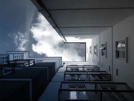 Low angle view of modern building facade against a cloudy sky, showcasing architectural design.