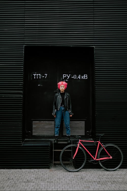 Woman in Leather Jacket Standing Beside a Double Doors