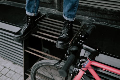 Orang Dengan Jeans Denim Biru Dan Sepatu Bot Kulit Hitam Berdiri Di Tangga Metal Hitam