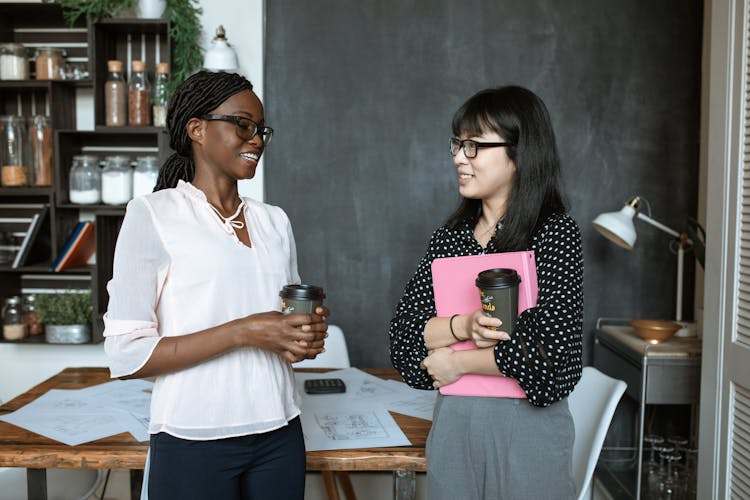 Two Women Standing In The Office Talking