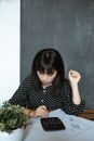 在现代办公室中，亚洲女性负责财务计算，专注于文档和设计工作