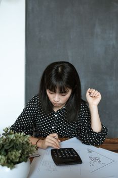在现代办公室中，亚洲女性负责财务计算，专注于文档和设计工作